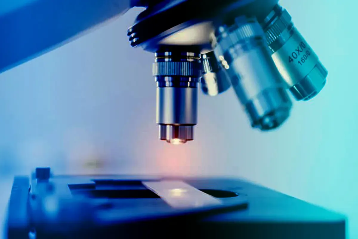 A pipette dropping liquid over a DNA helix, representing biotech research and revenue.